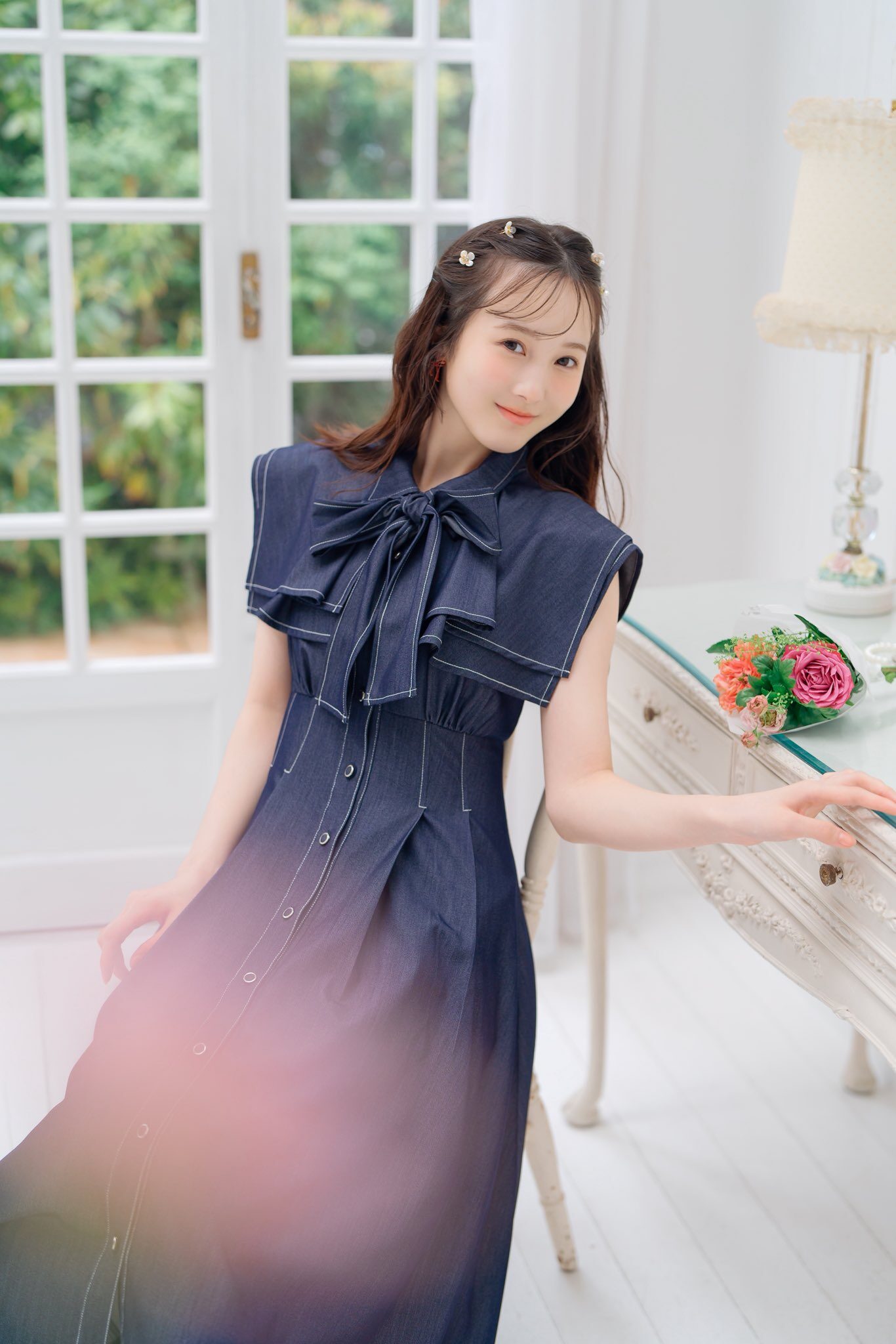 笑顔の本田紗来が椅子に寄りかかっている