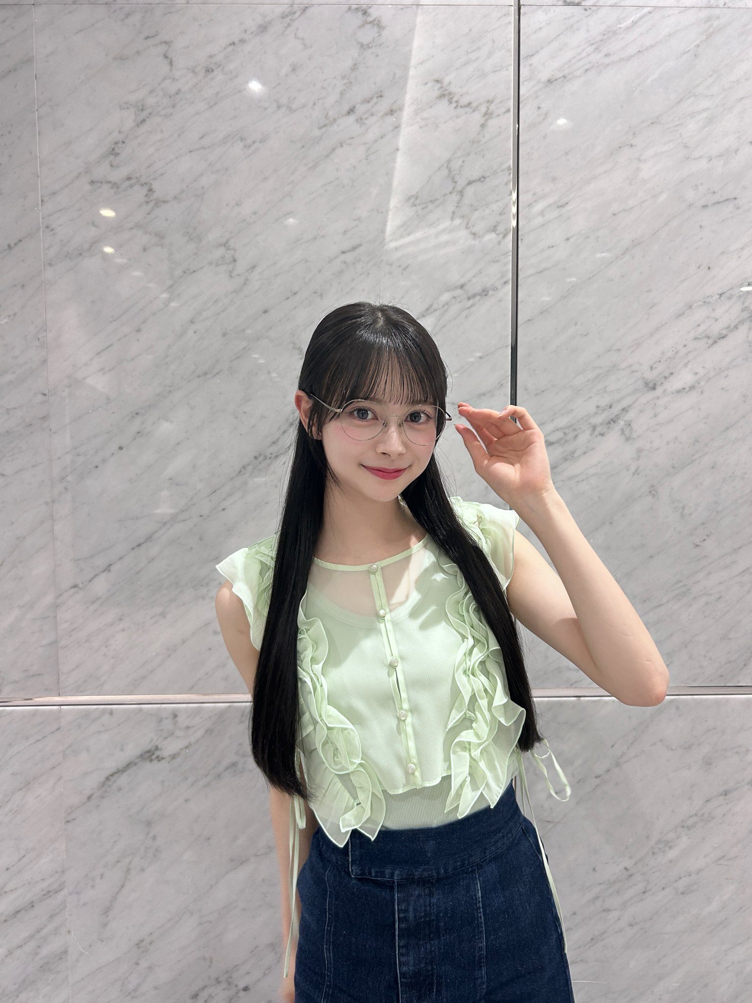 メガネ姿の伊藤百花が左手でメガネを触ろうとしている