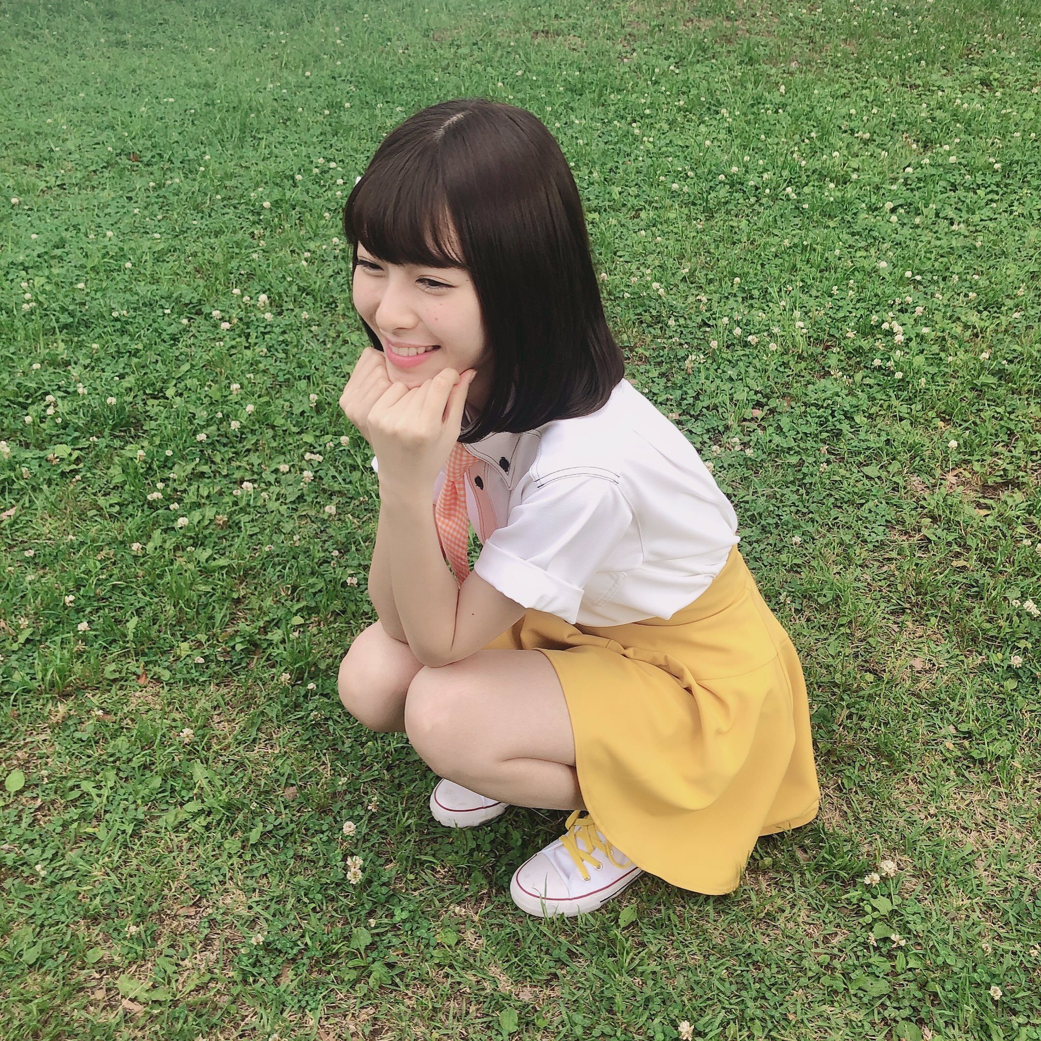 白石聖がぶりっ子ポーズでしゃがんでいる(少し右向いている)