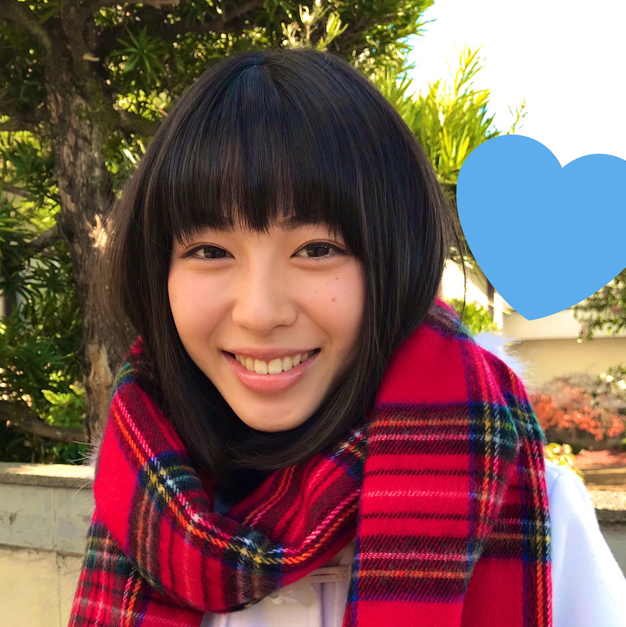 笑顔の白石聖の上半身、首にマフラーを巻いている