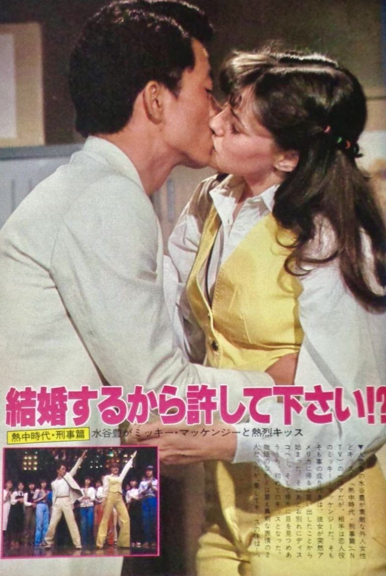 水谷豊とミッキー・マッケンジーがキスをしている