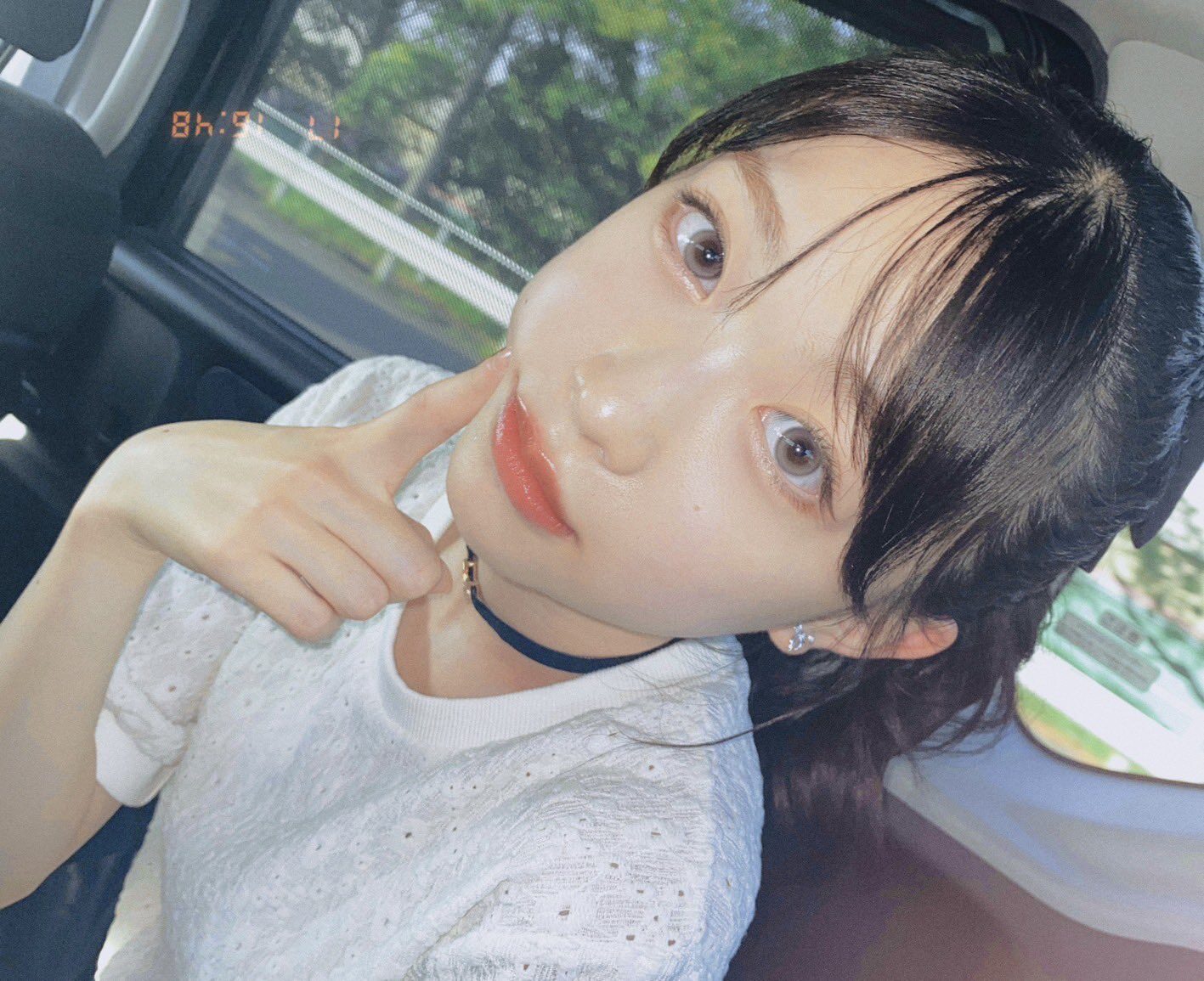 五藤希愛が車内で右人差し指で頬をツンとしている
