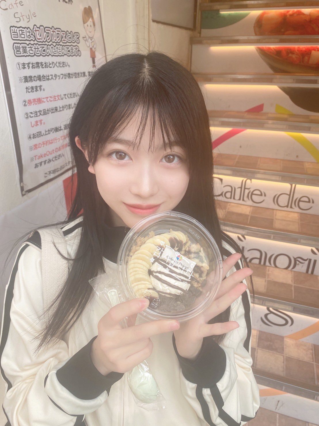五藤希愛が両手でスイーツを持ってこちらに見せている