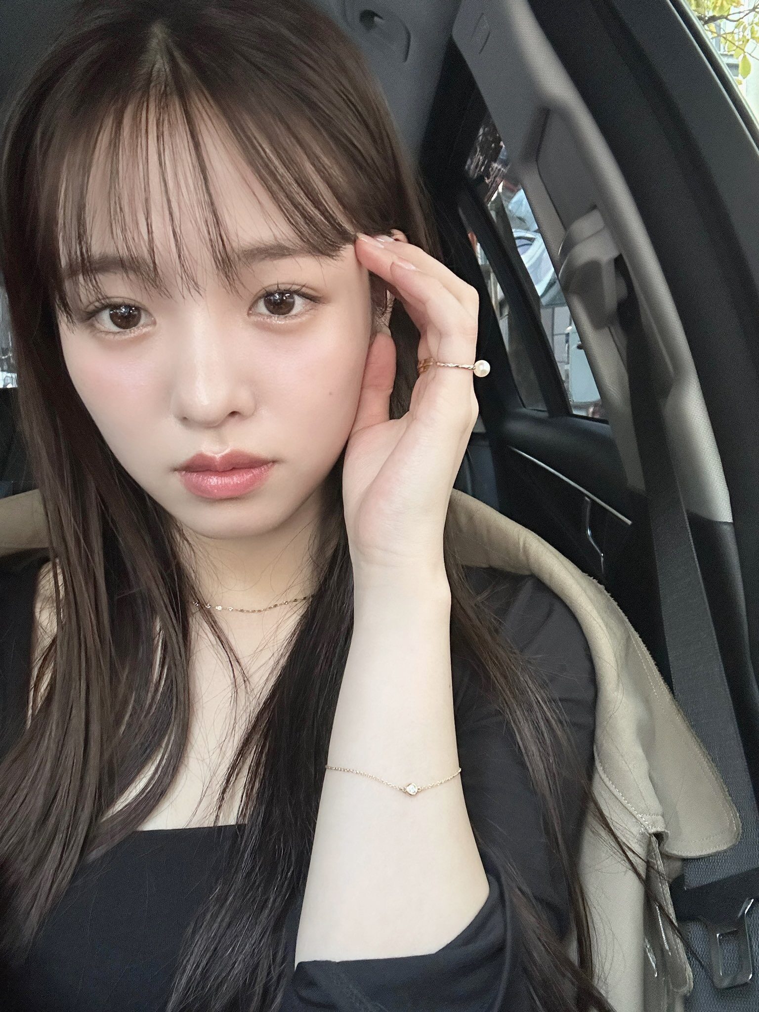 車の中の横田真悠の上半身、左手で髪をかき上げている